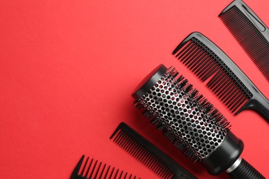 Photo of Different hairdresser's tools on red background, flat lay. Space for text