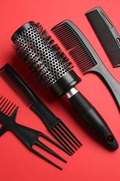 Photo of Different hairdresser's tools on red background, flat lay
