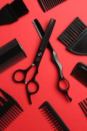 Photo of Different hairdresser's tools on red background, flat lay