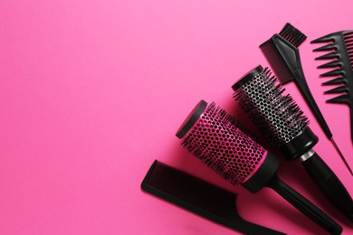 Photo of Different hairdresser's tools on pink background, flat lay. Space for text