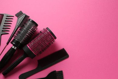 Photo of Different hairdresser's tools on pink background, flat lay. Space for text