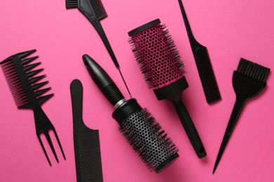Photo of Different hairdresser's tools on pink background, flat lay