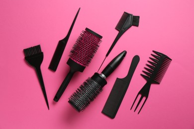 Photo of Different hairdresser's tools on pink background, flat lay