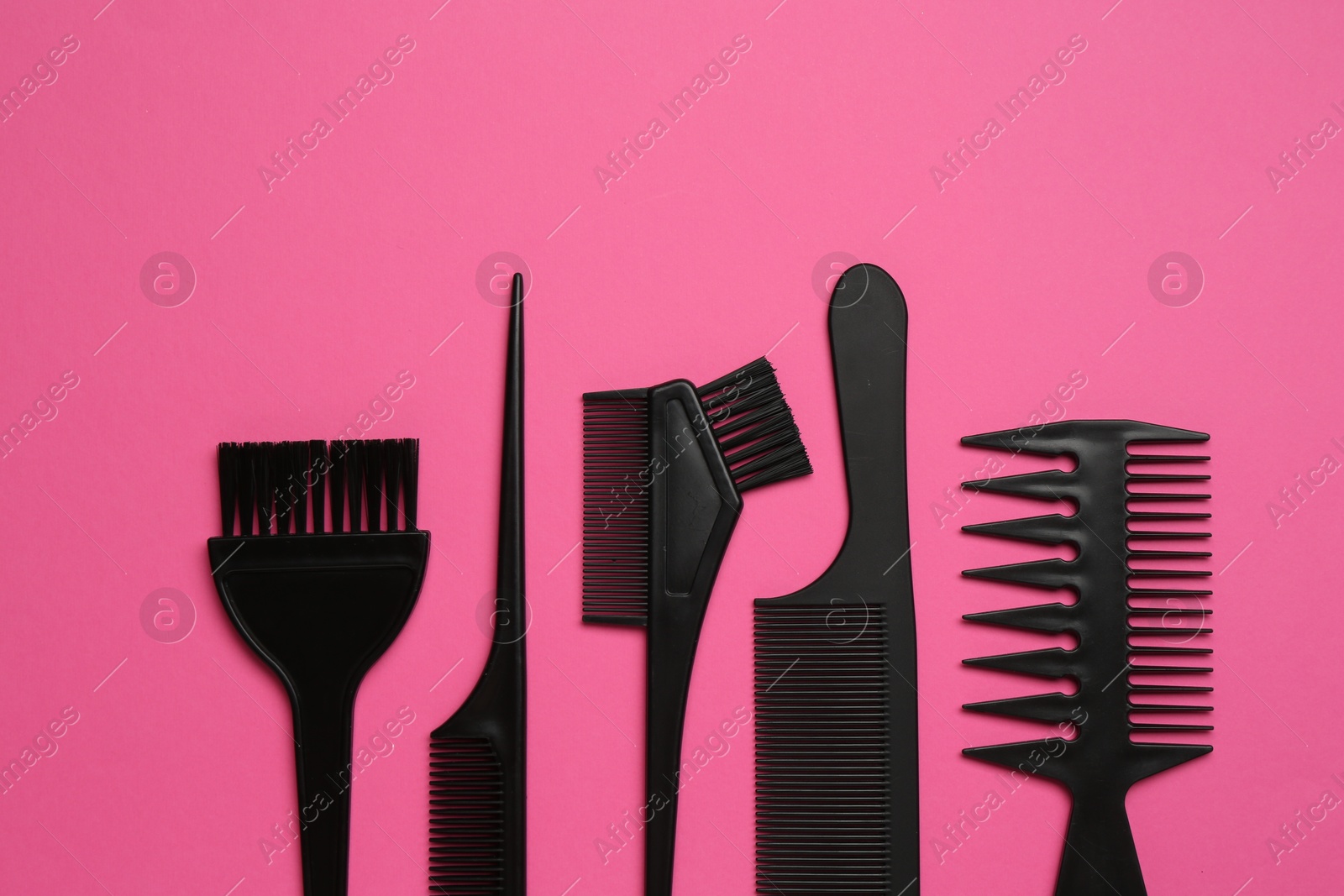 Photo of Different hairdresser's tools on pink background, flat lay