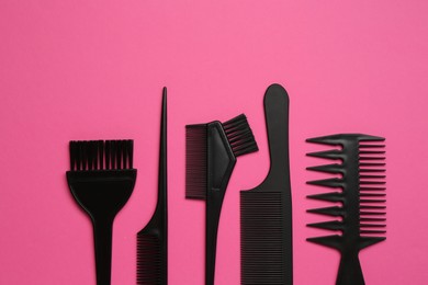 Photo of Different hairdresser's tools on pink background, flat lay