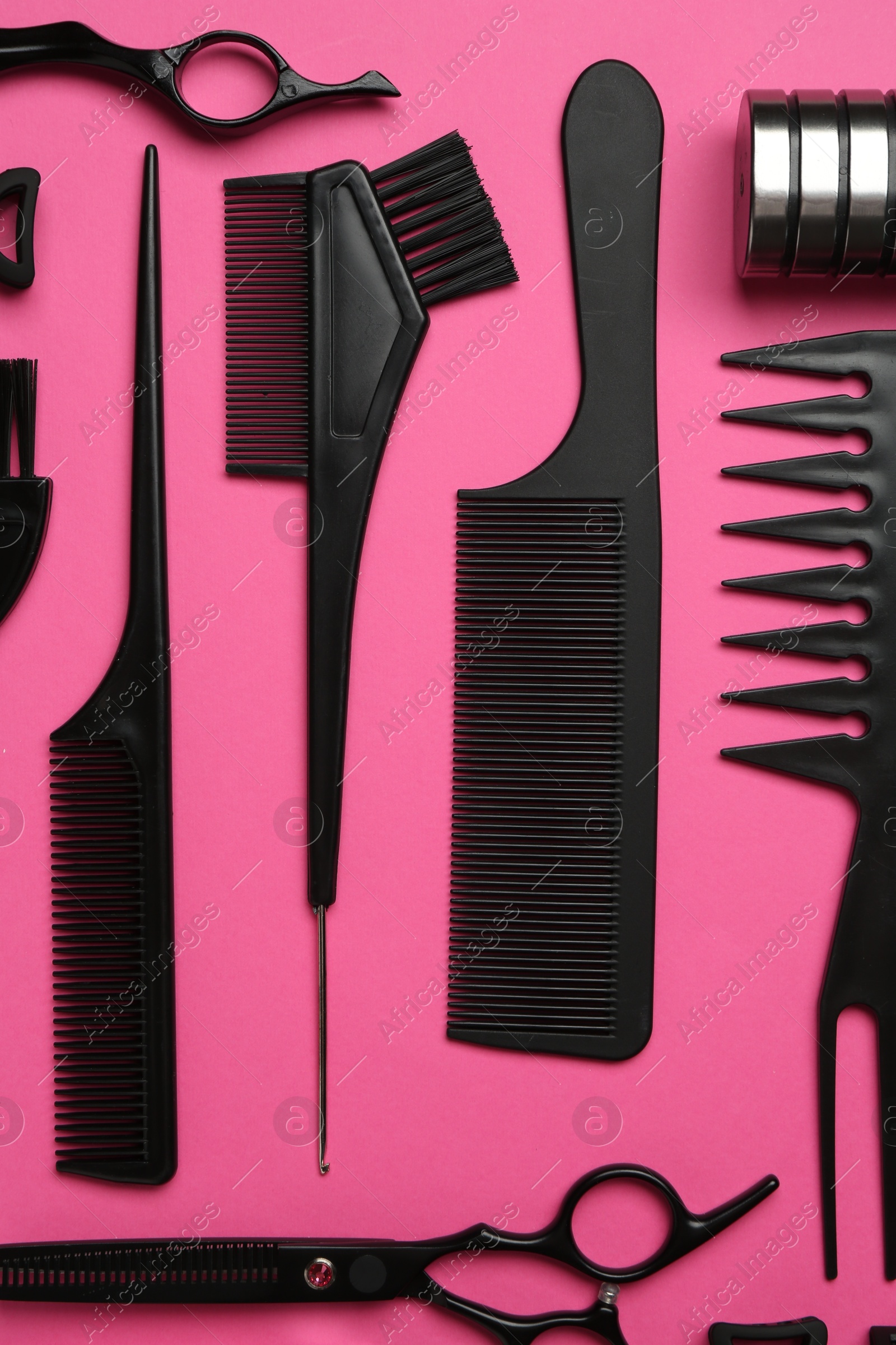 Photo of Different hairdresser's tools on pink background, flat lay