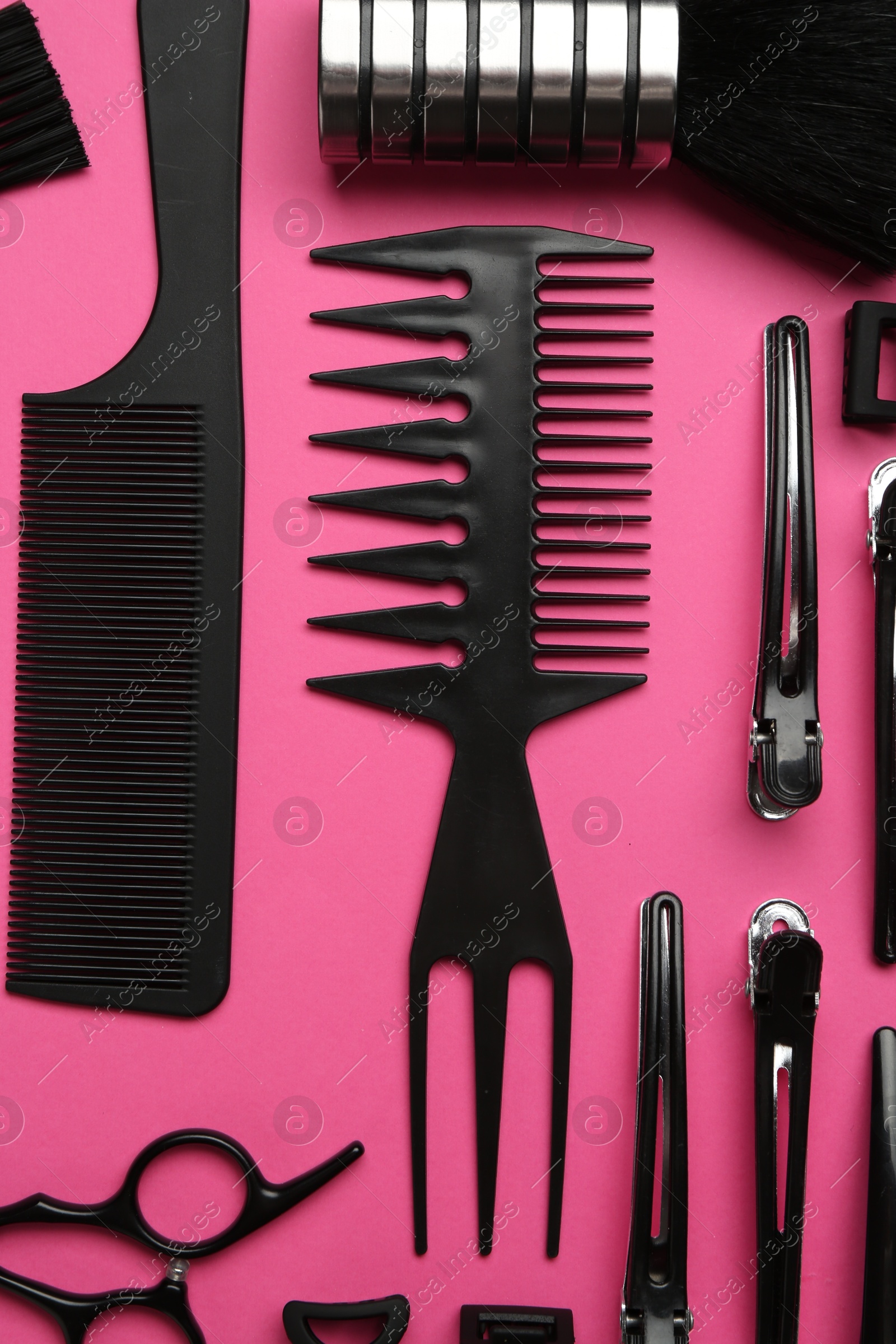 Photo of Different hairdresser's tools on pink background, flat lay