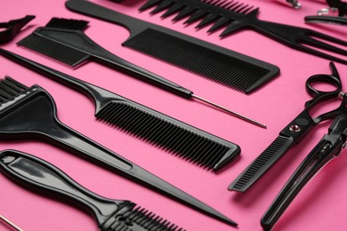 Photo of Different hairdresser's tools on pink background, closeup