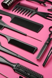Photo of Different hairdresser's tools on pink background, closeup