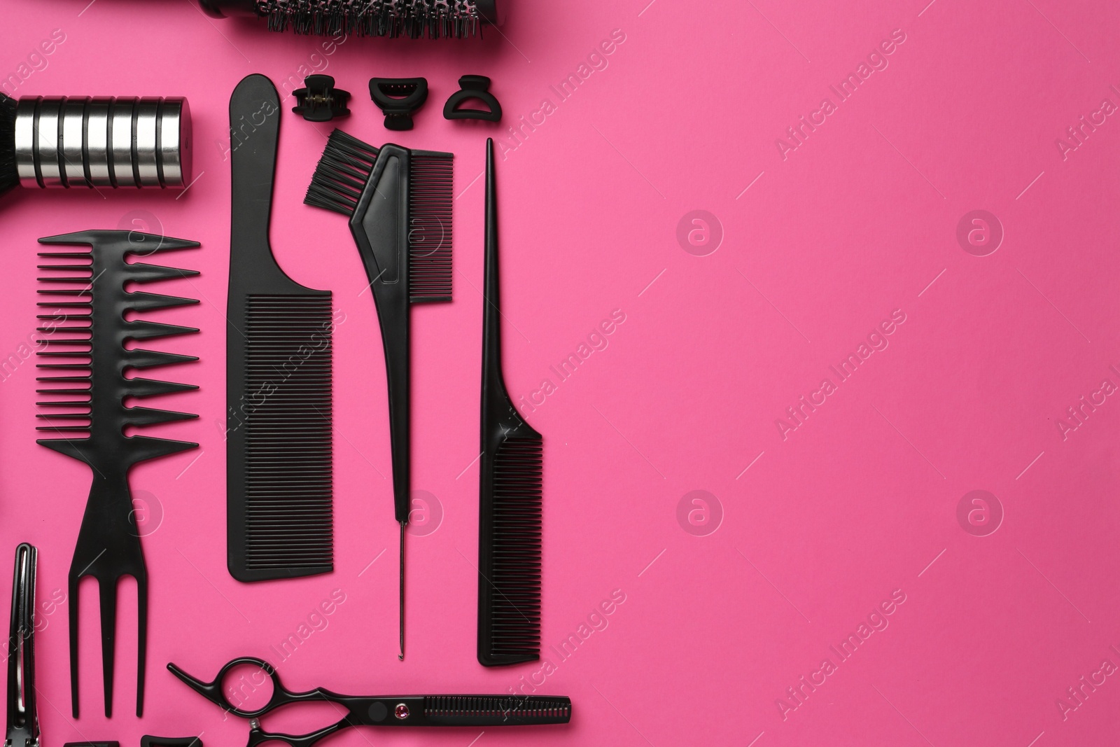 Photo of Different hairdresser's tools on pink background, flat lay. Space for text