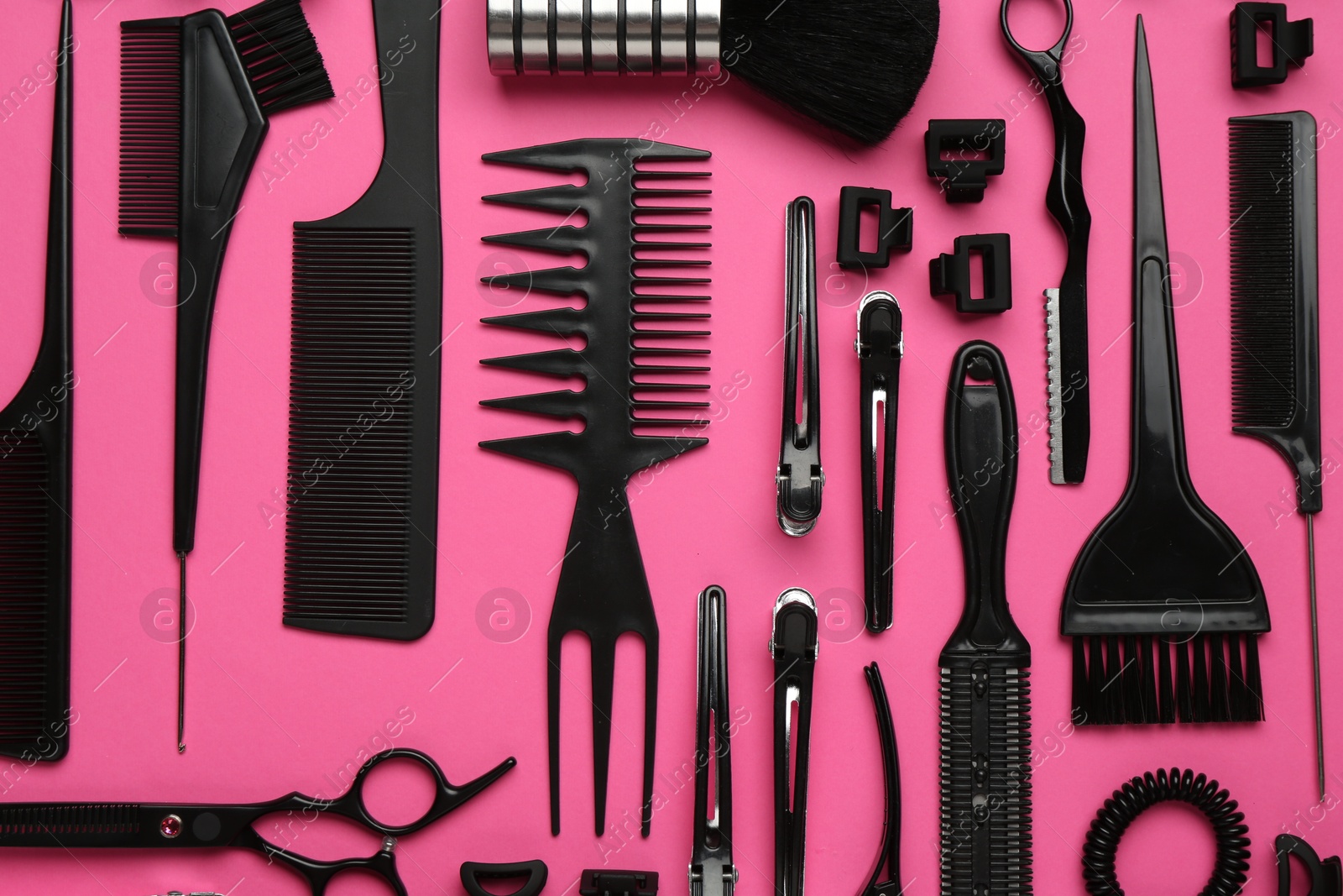 Photo of Different hairdresser's tools on pink background, flat lay