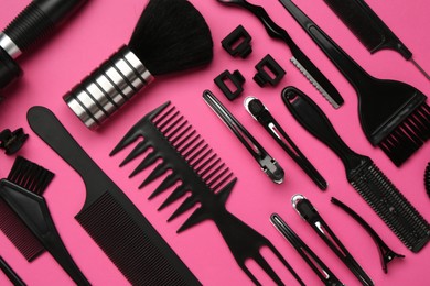 Photo of Different hairdresser's tools on pink background, flat lay