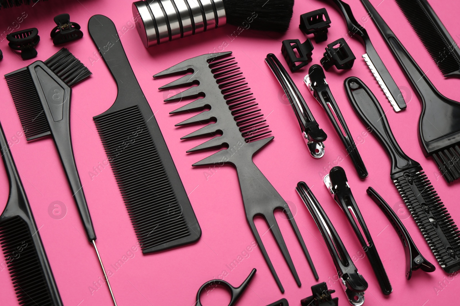 Photo of Different hairdresser's tools on pink background, above view