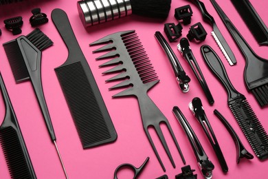 Photo of Different hairdresser's tools on pink background, above view