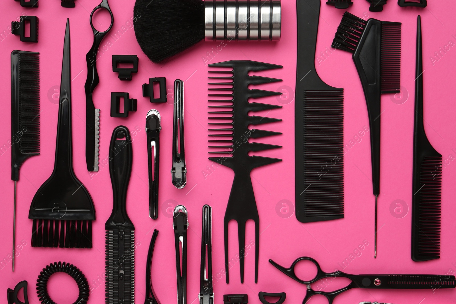 Photo of Different hairdresser's tools on pink background, flat lay