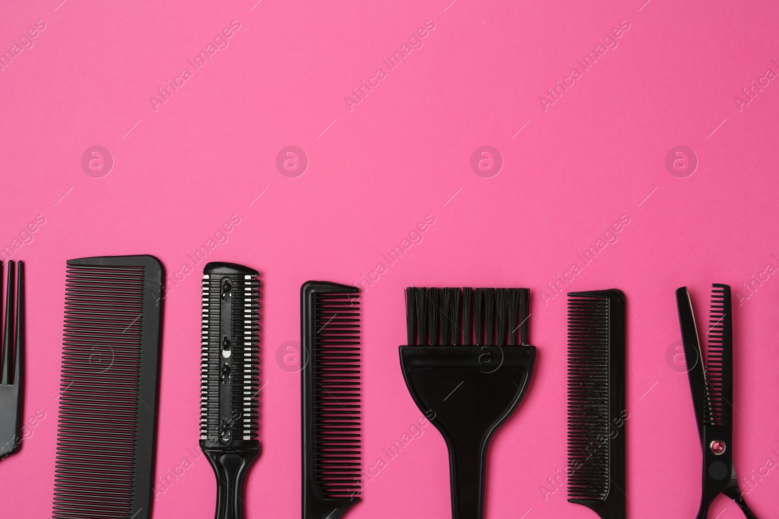 Photo of Different hairdresser's tools on pink background, flat lay. Space for text