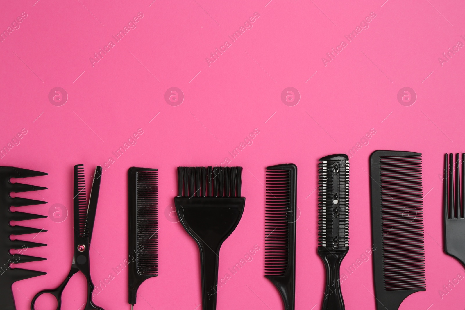 Photo of Different hairdresser's tools on pink background, flat lay. Space for text