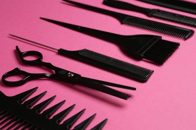 Photo of Different hairdresser's tools on pink background, closeup