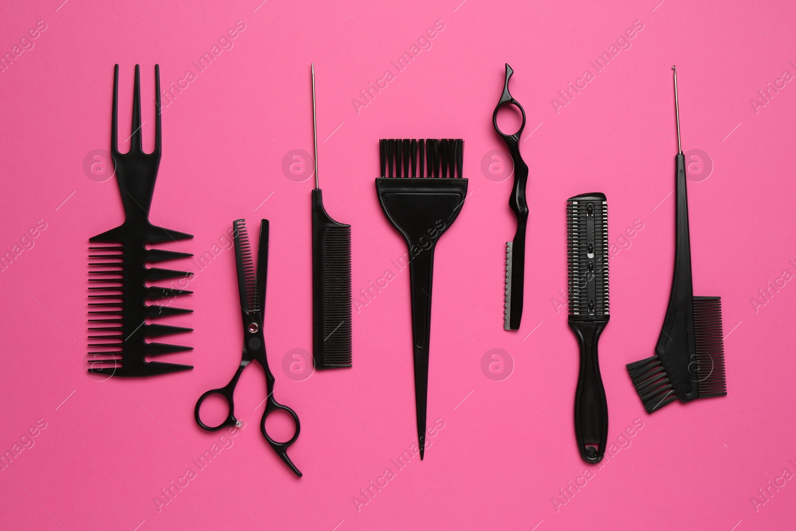 Photo of Different hairdresser's tools on pink background, flat lay