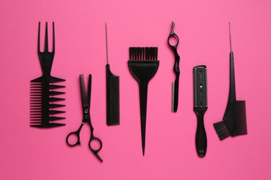 Photo of Different hairdresser's tools on pink background, flat lay