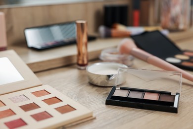 Photo of Different makeup products and brush on vanity indoors, closeup