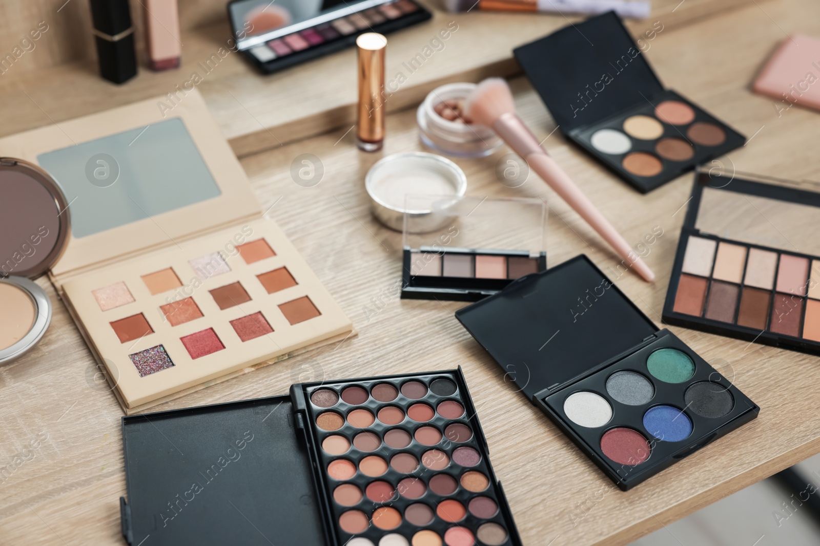 Different makeup products and brush on vanity indoors Photo of Different makeup products and brush on vanity indoors