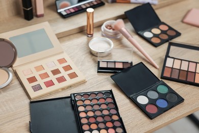 Photo of Different makeup products and brush on vanity indoors