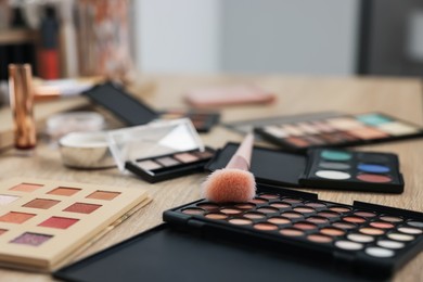 Photo of Different makeup products and brush on vanity indoors, closeup