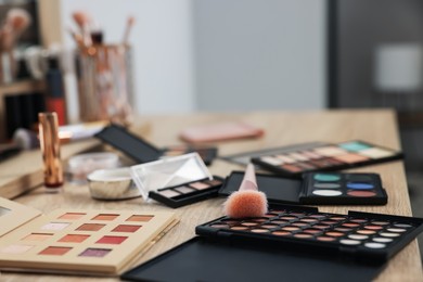 Photo of Different makeup products and brush on vanity indoors, closeup