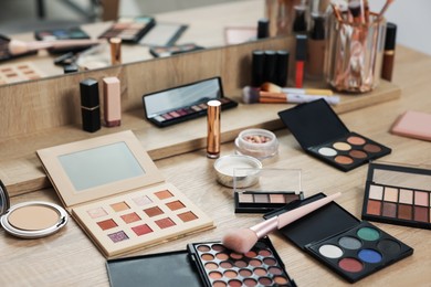 Photo of Different makeup products and brush on vanity indoors
