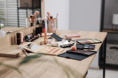 Photo of Different makeup products and brush on vanity indoors