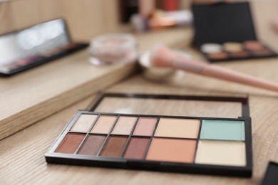 Photo of Palette with eyeshadows and color correctors on vanity indoors, closeup