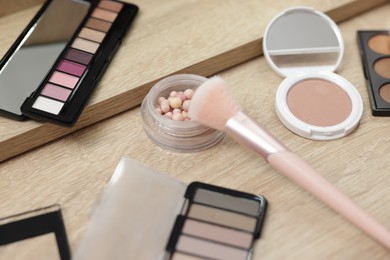 Photo of Different makeup products and brush on vanity indoors, closeup