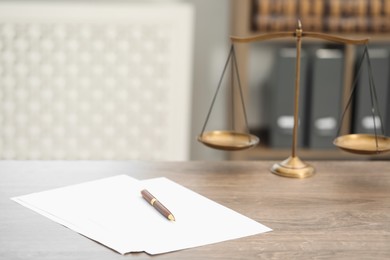 Photo of Judge's workplace with papers and scales on wooden table in office, closeup