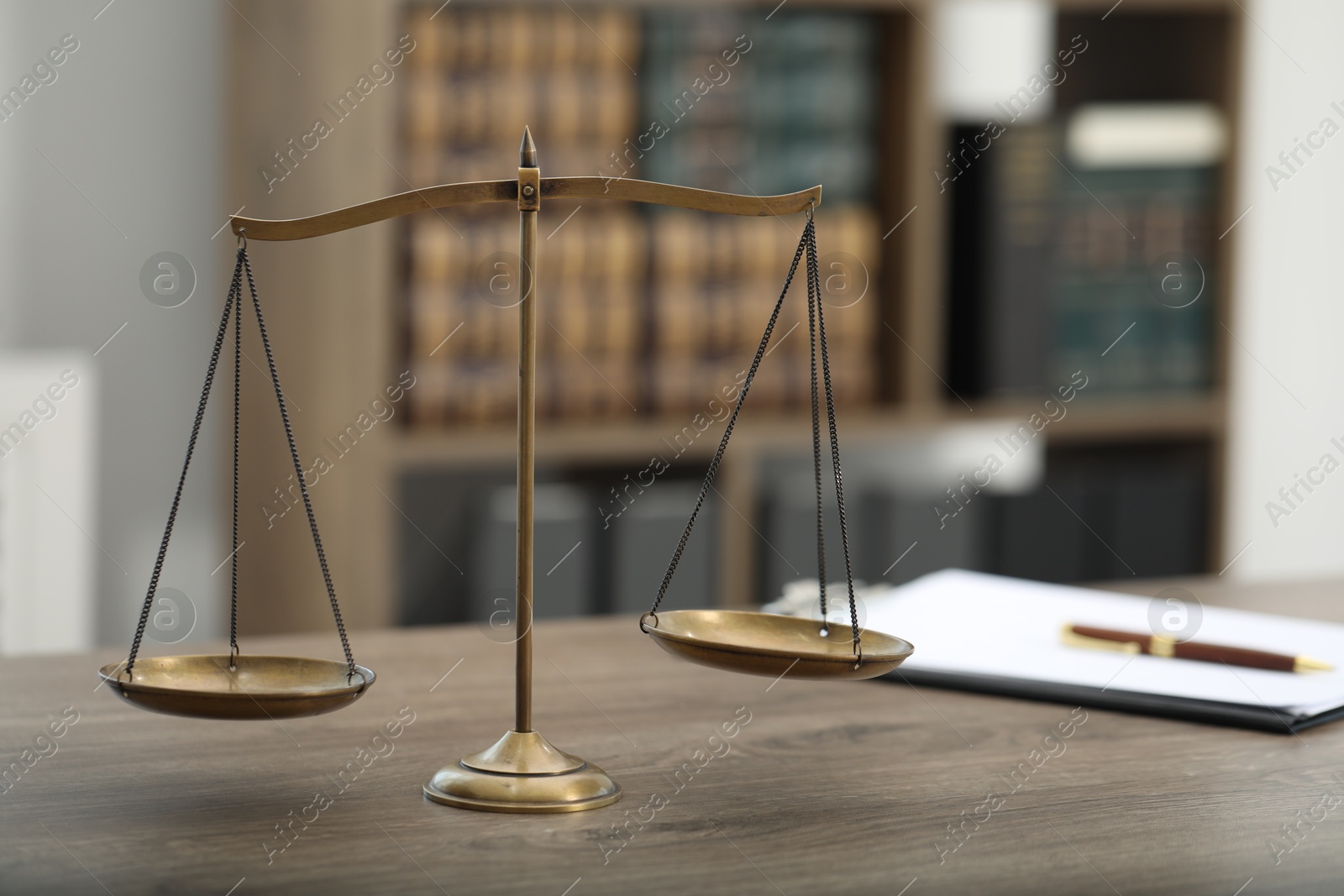 Photo of Judge's workplace with scales and clipboard on wooden table in office, closeup