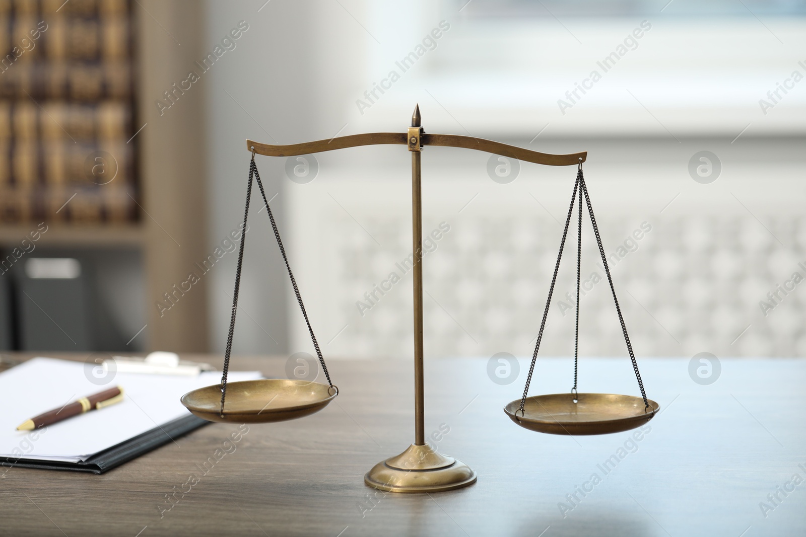 Photo of Judge's workplace with scales and clipboard on wooden table in office, closeup