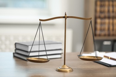 Photo of Judge's workplace with scales, books and clipboard on wooden table in office, closeup