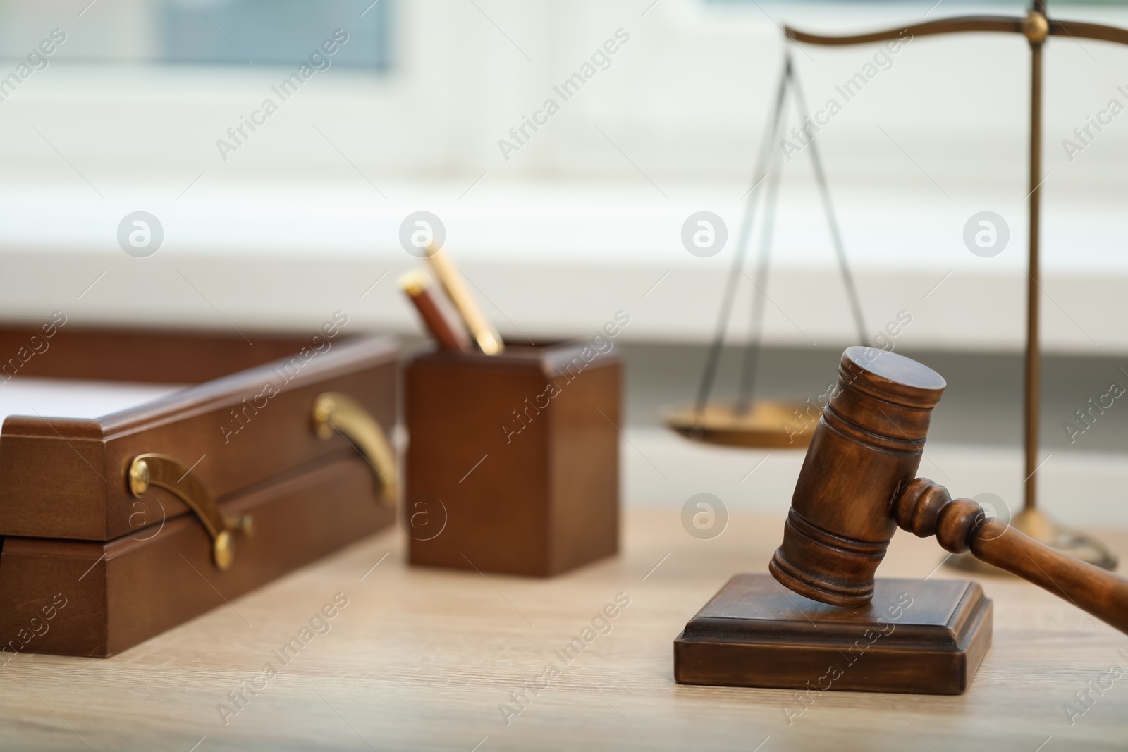 Judge's gavel and scales on wooden table in office, closeup Photo of Judge's gavel and scales on wooden table in office, closeup