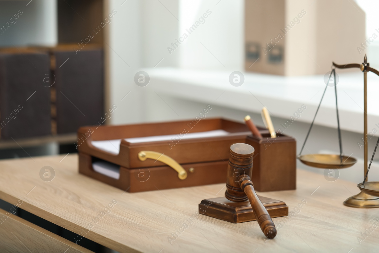 Judge's gavel and scales on wooden table in office Photo of Judge's gavel and scales on wooden table in office