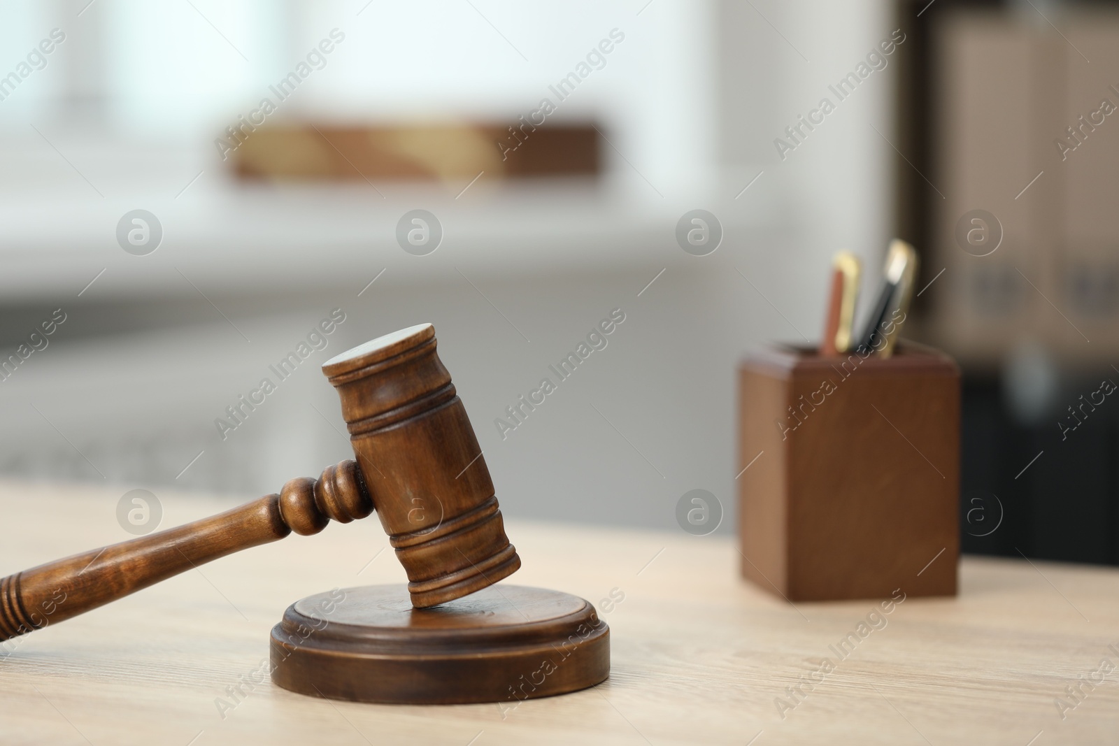 Judge's gavel and stationery on wooden table in office, closeup Photo of Judge's gavel and stationery on wooden table in office, closeup