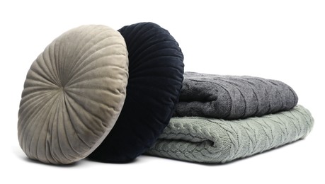 Photo of Folded woolen blankets and pillows isolated on white