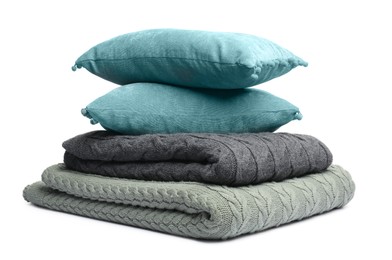Photo of Folded woolen blankets and pillows isolated on white