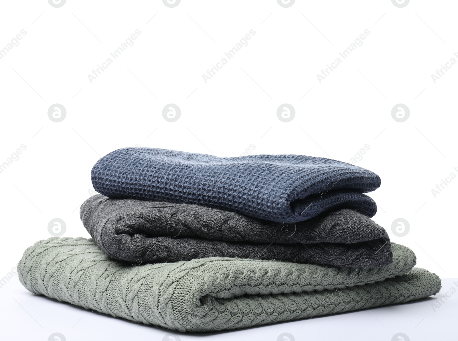 Photo of Stack of folded blankets on white background