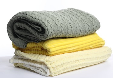 Photo of Stack of folded woolen blankets on white background