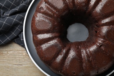 Photo of Tasty chocolate bundt cake on wooden table, top view