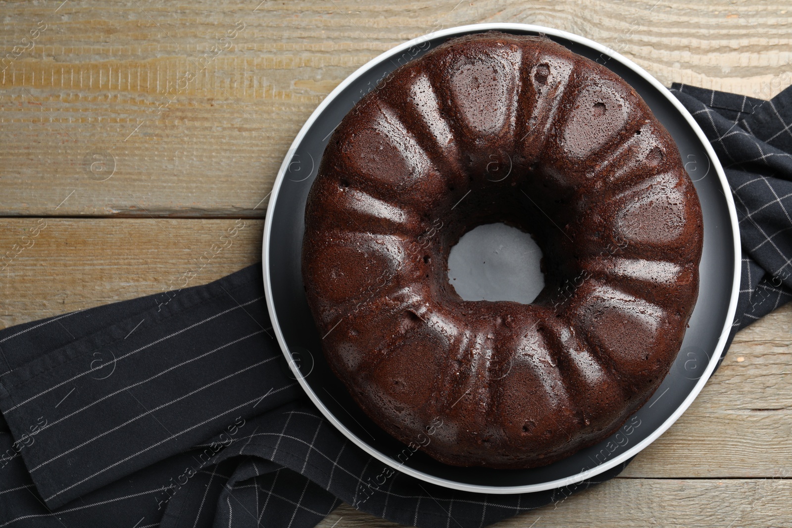 Tasty chocolate bundt cake on wooden table, top view Photo of Tasty chocolate bundt cake on wooden table, top view