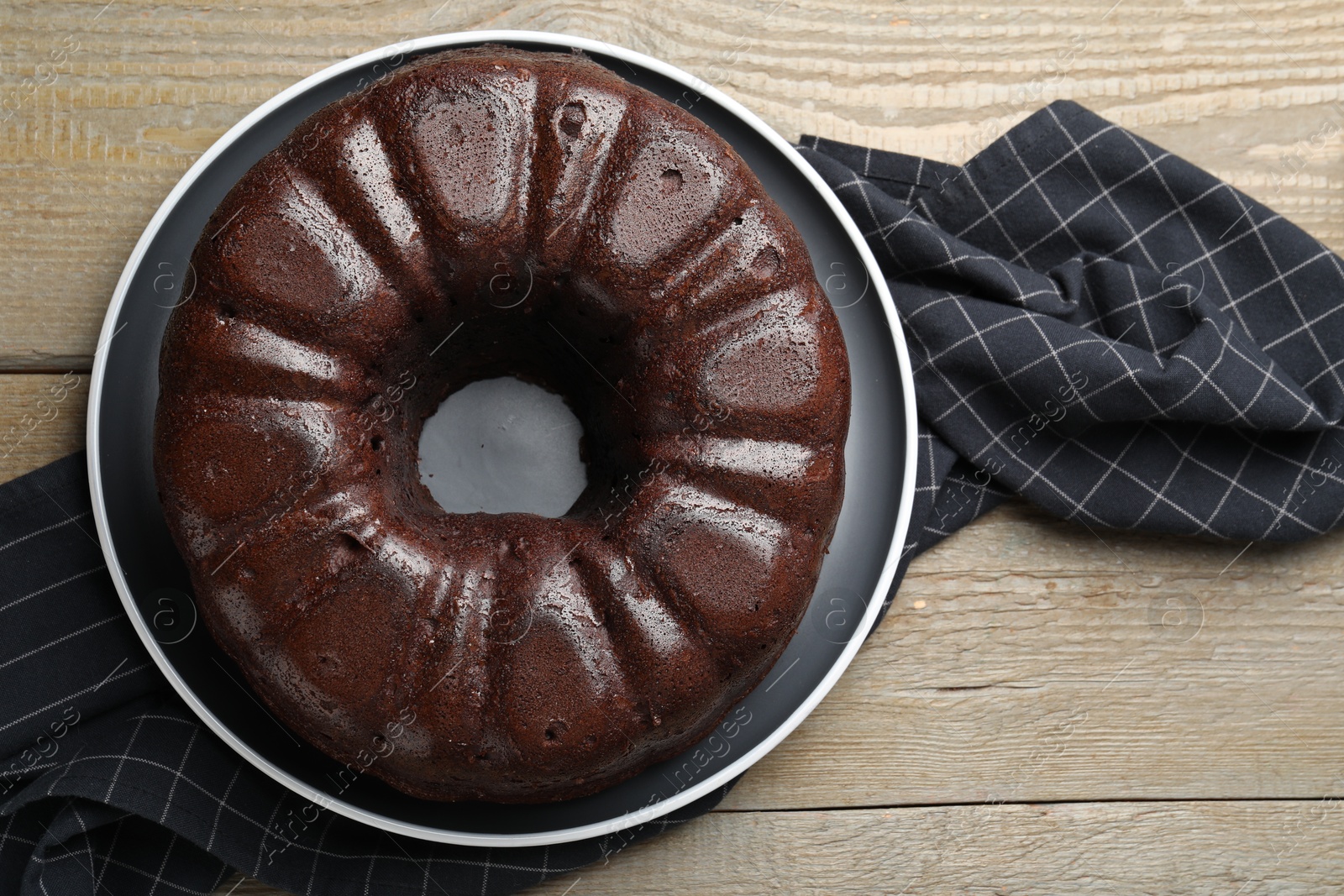 Tasty chocolate bundt cake on wooden table, top view Photo of Tasty chocolate bundt cake on wooden table, top view