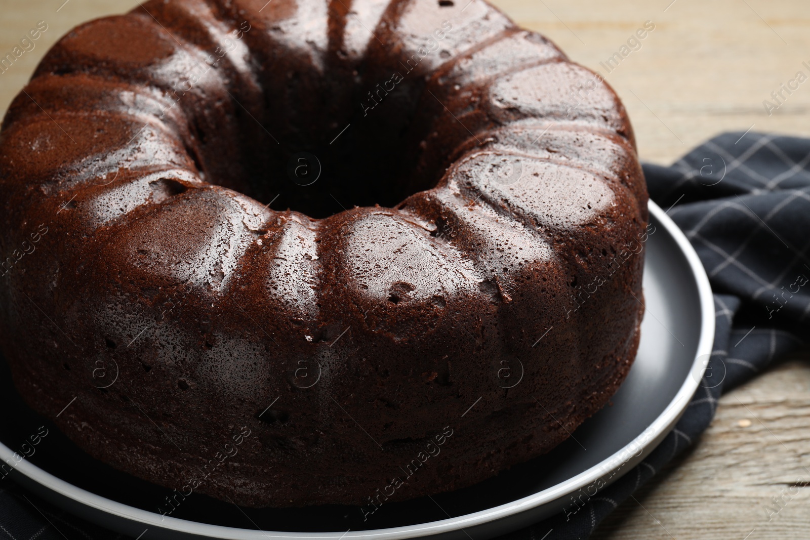 Tasty chocolate bundt cake on wooden table, closeup Photo of Tasty chocolate bundt cake on wooden table, closeup