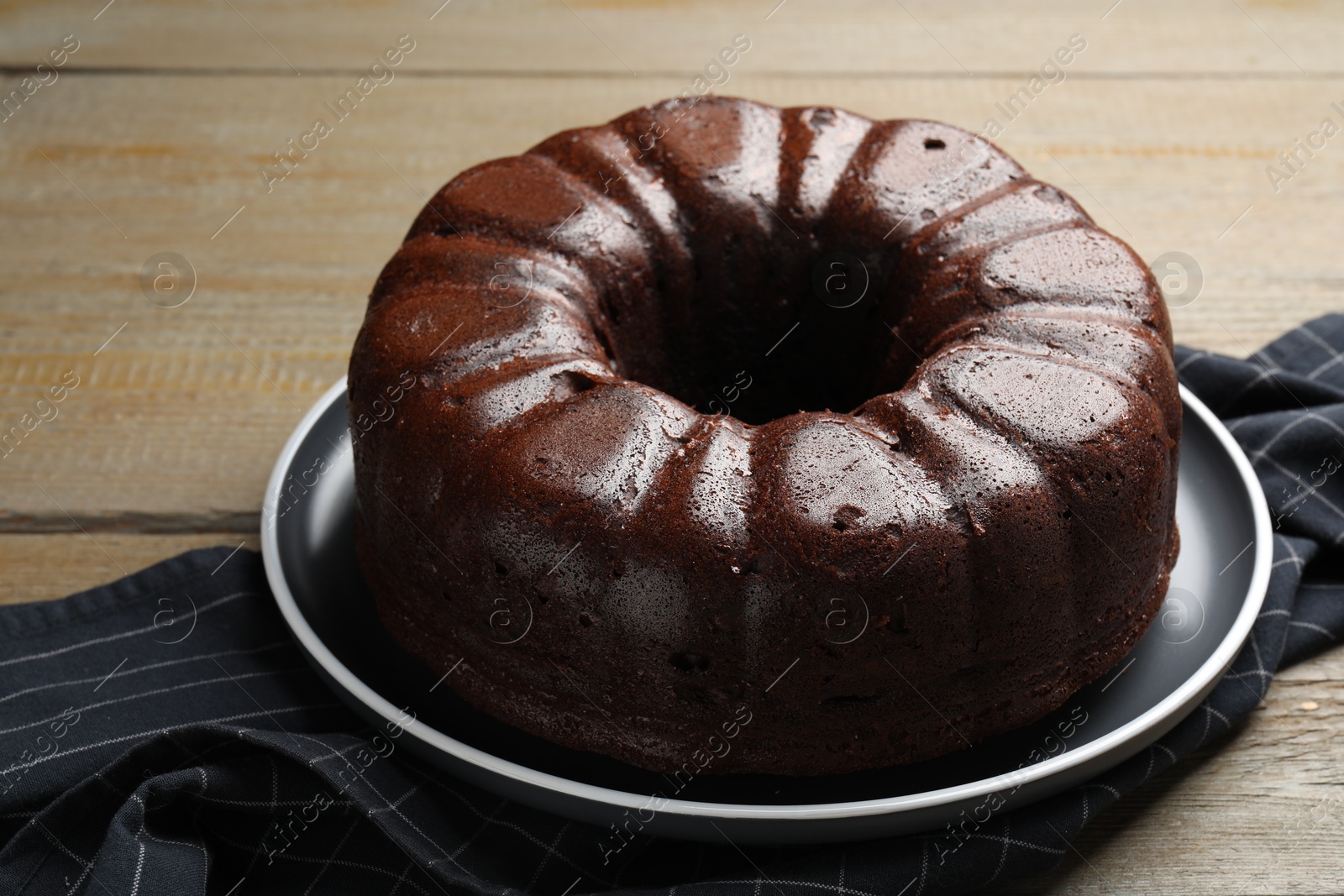 Tasty chocolate bundt cake on wooden table, closeup Photo of Tasty chocolate bundt cake on wooden table, closeup
