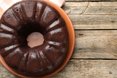 Photo of Tasty chocolate bundt cake on wooden table, top view. Space for text